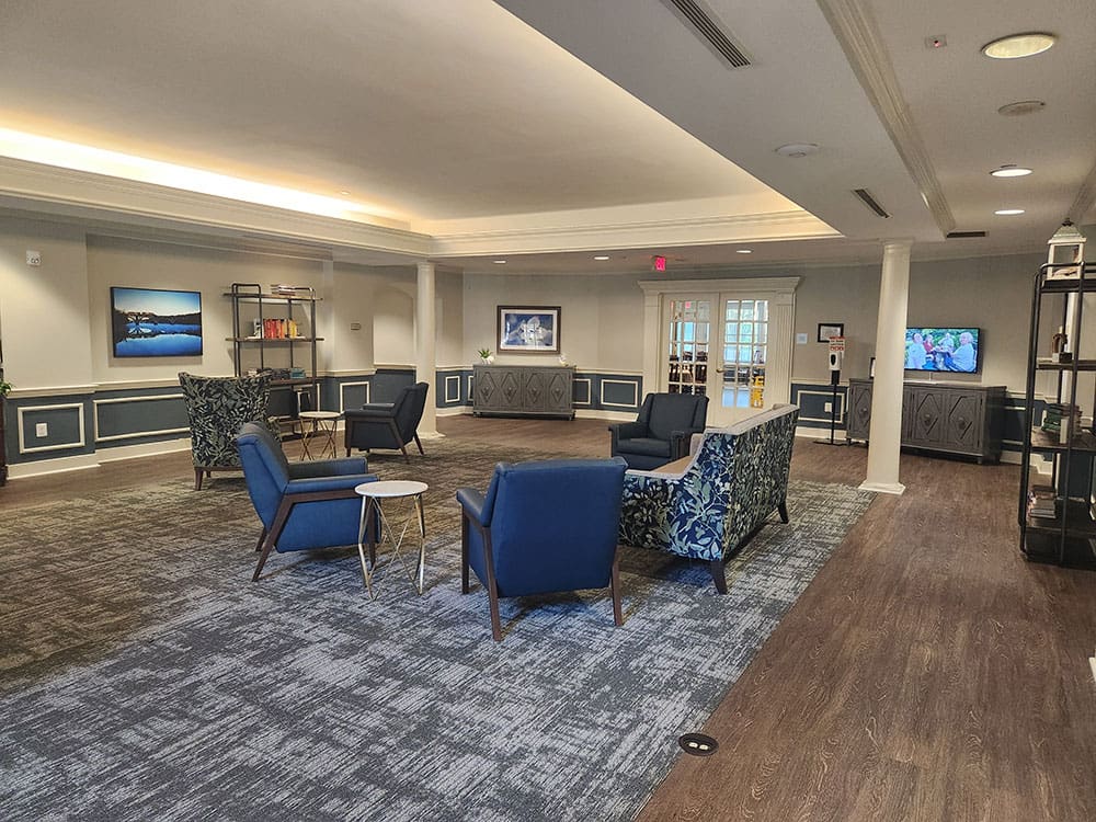 large community room with seating, artwork, bookcases and tv