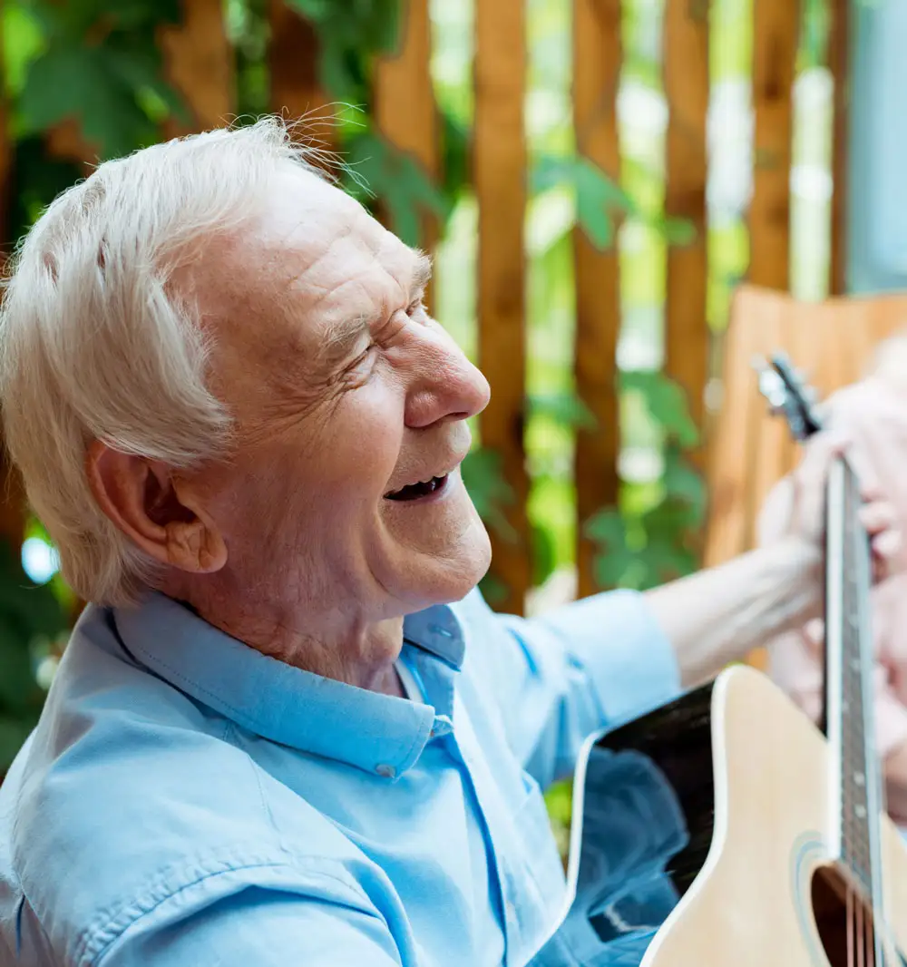 man smiling with guitar
